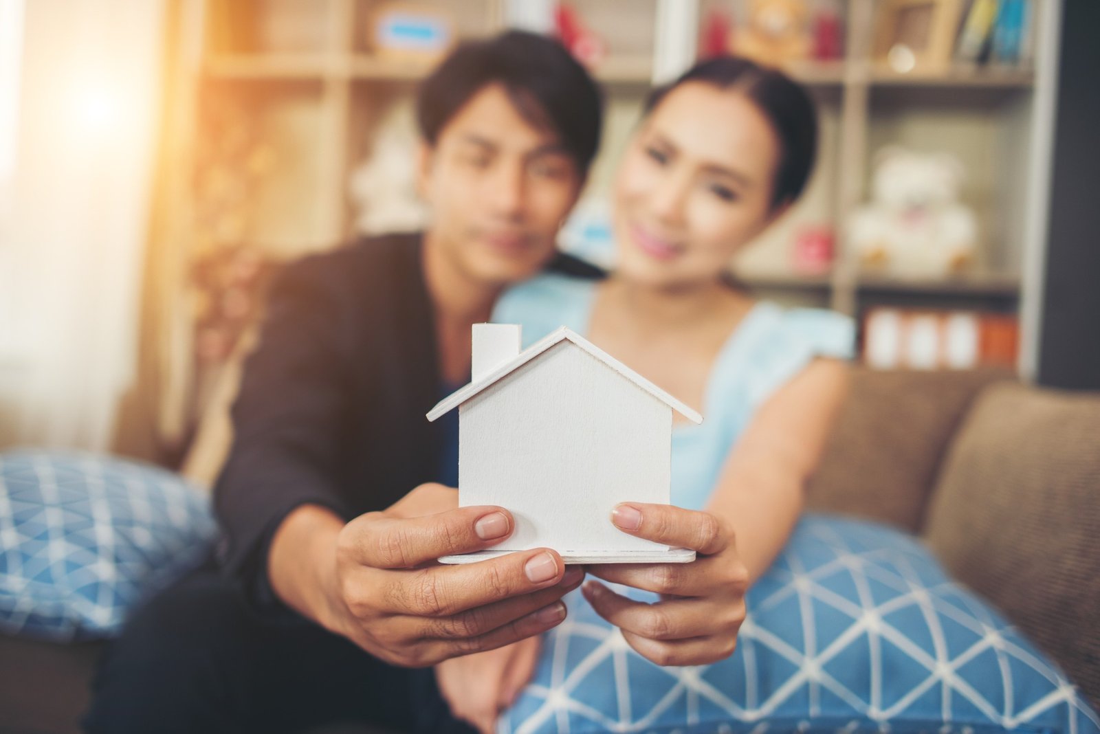 young couple holding white miniature house living room 1 1 1